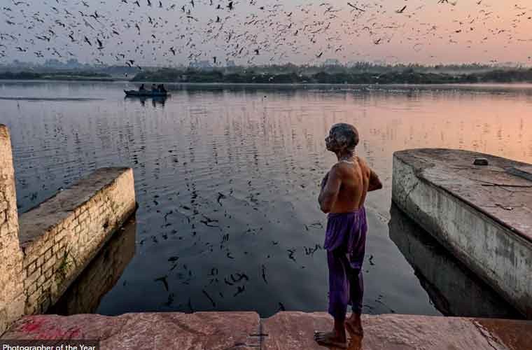 Một bức  ảnh đời thường ghi lại cảnh người đàn ông tắm bên bờ sông Yamuna, con sông linh thiêng nhất và cũng là sông ô nhiễm nhất ở Ấn Độ.